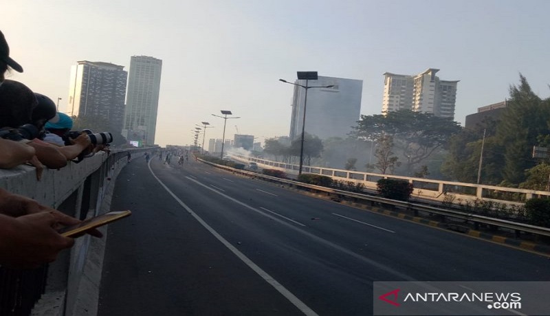 Polisi menembak gas air mata ke arah pedemo di ruas Tol Semanggi, Jakarta. Foto: Antara Polisi menembak gas air mata ke arah pedemo di ruas Tol Semanggi, Jakarta. Foto: Antara