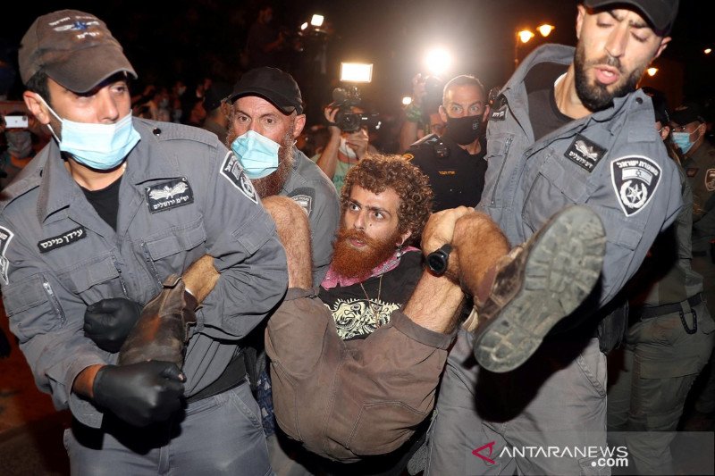 Polisi menahan seorang pria saat aksi protes mengecam Perdana Menteri Benjamin Netanyahu dan pemerintahan yang dipimpinnya atas penanganan krisis penyakit virus corona (COVID-19), dekat kediaman Netanyahu di Yerusalem, Kamis (23/7/2020). (Foto: Antara/Reu Polisi menahan seorang pria saat aksi protes mengecam Perdana Menteri Benjamin Netanyahu dan pemerintahan yang dipimpinnya atas penanganan krisis penyakit virus corona (COVID-19), dekat kediaman Netanyahu di Yerusalem, Kamis (23/7/2020). (Foto: Antara/Reu