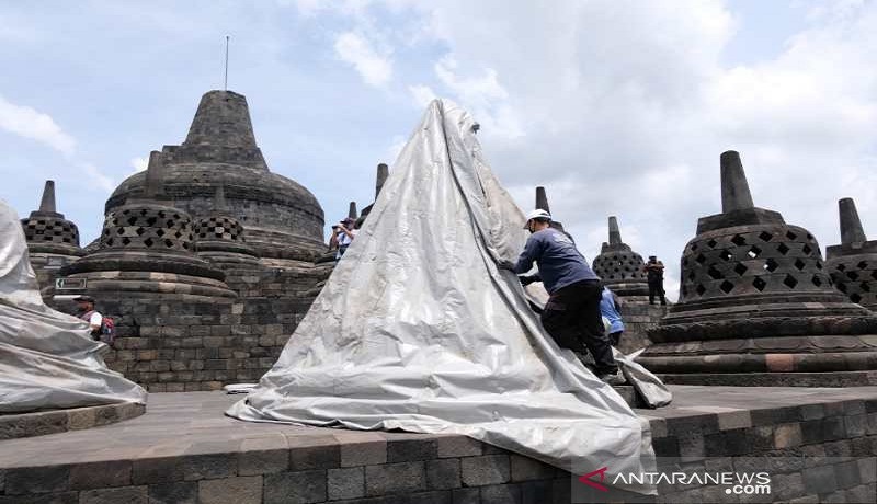Petugas menutup stupa candi dengan terpal putih untuk mengantisipasi erupsi Gunung Merapi. Foto: Antara/Anis Efizudin Petugas menutup stupa candi dengan terpal putih untuk mengantisipasi erupsi Gunung Merapi. Foto: Antara/Anis Efizudin