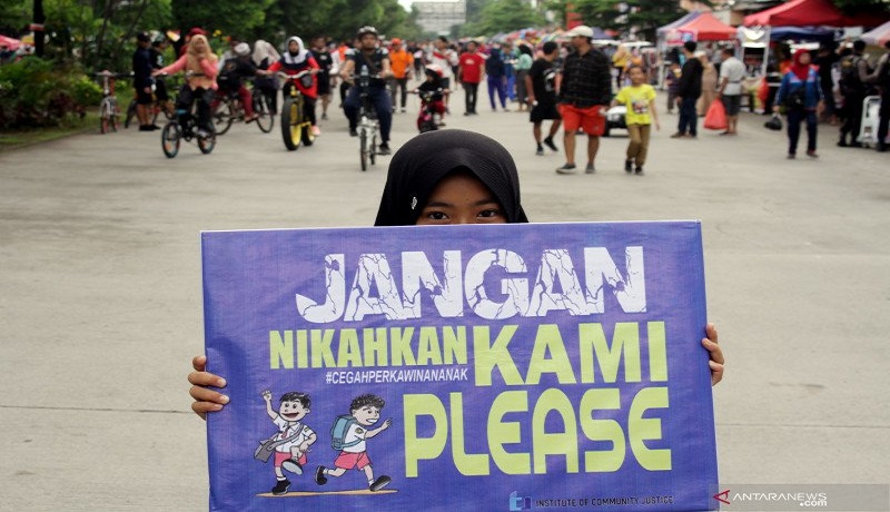 Seorang anak membawa poster saat aksi peringatan Hari Perempuan Internasional. FOTO: Antara Seorang anak membawa poster saat aksi peringatan Hari Perempuan Internasional. FOTO: Antara