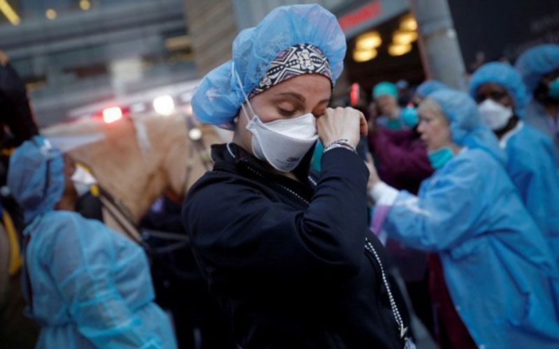 Petugas medis tengah mengusap air mata. Foto: Reuters. Petugas medis tengah mengusap air mata. Foto: Reuters.