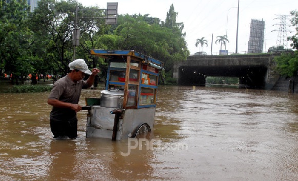 Warga melintas saat banjir yang merendam kawasan Cawang, Jakarta, Rabu (1/1). Banjir tersebut membuat lalu lintas kawasan Cawang lumpuh. (Foto : Ricardo/JPNN) Warga melintas saat banjir yang merendam kawasan Cawang, Jakarta, Rabu (1/1). Banjir tersebut membuat lalu lintas kawasan Cawang lumpuh. (Foto : Ricardo/JPNN)