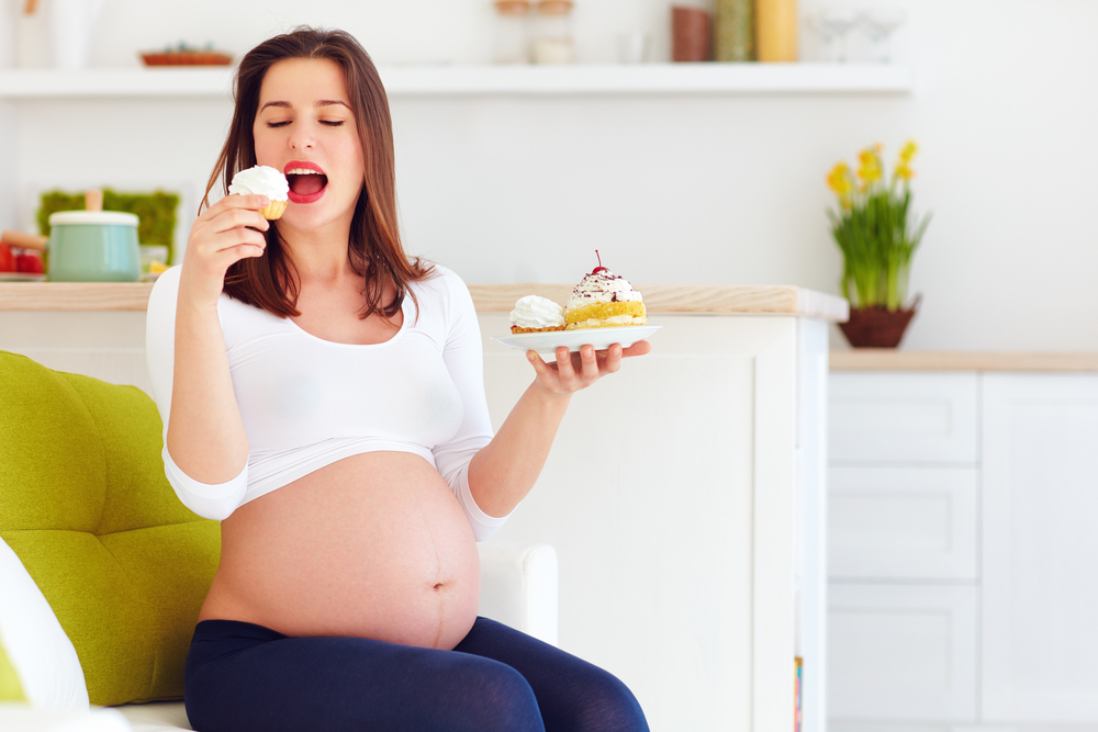 Ilustrasi ibu hamil makan makanan manis. Foto: Shutterstock Ilustrasi ibu hamil makan makanan manis. Foto: Shutterstock