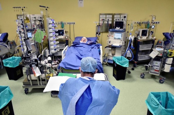 Seorang staf medis dengan pakaian pelindung terlihat di depan seorang pasien dengan penyakit virus korona (COVID-19) di dalam sebuah ICU di RS San Raffaele, Milan, Italia, Jumat (27/3). (Foto: REUTERS/FLAVIO LO SCALZO) Seorang staf medis dengan pakaian pelindung terlihat di depan seorang pasien dengan penyakit virus korona (COVID-19) di dalam sebuah ICU di RS San Raffaele, Milan, Italia, Jumat (27/3). (Foto: REUTERS/FLAVIO LO SCALZO)