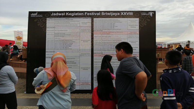 Warga melihat jadwal Festival Sriwijaya 2019 (foto: Robby Sunata) Warga melihat jadwal Festival Sriwijaya 2019 (foto: Robby Sunata)