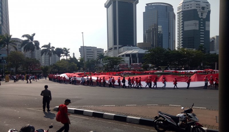 Bendera raksasa sepanjang 200 meter dibentangkan relawan Jokowi-Maruf di Bunderan Patung Kuda, Monas. Foto: Antara Bendera raksasa sepanjang 200 meter dibentangkan relawan Jokowi-Maruf di Bunderan Patung Kuda, Monas. Foto: Antara