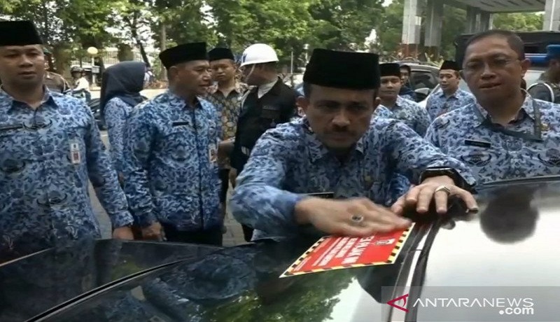 Wali Kota Jakarta Timur, M Anwar, menempel stiker di salah satu kaca mobil milik Aparatur Sipil Negara (ASN) yang belum melunasi pajak kendaraan. Foto: Antara Wali Kota Jakarta Timur, M Anwar, menempel stiker di salah satu kaca mobil milik Aparatur Sipil Negara (ASN) yang belum melunasi pajak kendaraan. Foto: Antara