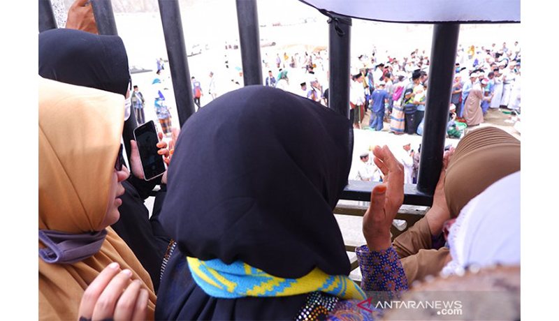 Istri Mbah Maimun Heni Maryam, menangis dan mendoakan sang suami tercinta di balik pagar pembatas pemakaman, yang baru saja selesai dimakamkan di Pemakaman Ma'la, Mekkah, Selasa (6/8/2019). (Sumber foto: Antaranews) Istri Mbah Maimun Heni Maryam, menangis dan mendoakan sang suami tercinta di balik pagar pembatas pemakaman, yang baru saja selesai dimakamkan di Pemakaman Ma'la, Mekkah, Selasa (6/8/2019). (Sumber foto: Antaranews)