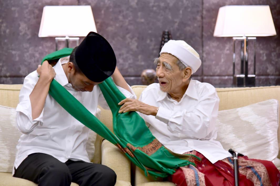 Momen ketika Mbah Moen mengalungkan sorban kepada Jokowi. (Foto: Biro Setpres) Momen ketika Mbah Moen mengalungkan sorban kepada Jokowi. (Foto: Biro Setpres)