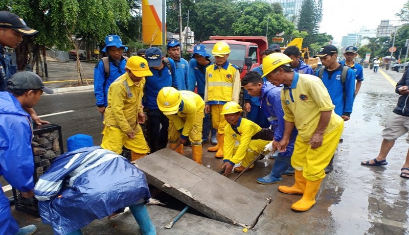 Para petugas suku dinas SDA, Bina Marga, dan Damkar Cikini membuka saluran air yang tersumbat di trotoar depan Pusat Kebudayaan Taman Ismail Marzuki, Sabtu (18/1). Foto: Antara Para petugas suku dinas SDA, Bina Marga, dan Damkar Cikini membuka saluran air yang tersumbat di trotoar depan Pusat Kebudayaan Taman Ismail Marzuki, Sabtu (18/1). Foto: Antara