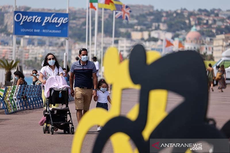 Wisatawan berjalan melintasi logo balap sepeda Tour De France edisi ke-107, di French Riviera, Nice, Prancis (26/8/) di tengah kehawatiran soal wabah virus corona (COVID-19). (Foto: Antara/AFP/Kenzo Tribouillard/aa.) Wisatawan berjalan melintasi logo balap sepeda Tour De France edisi ke-107, di French Riviera, Nice, Prancis (26/8/) di tengah kehawatiran soal wabah virus corona (COVID-19). (Foto: Antara/AFP/Kenzo Tribouillard/aa.)