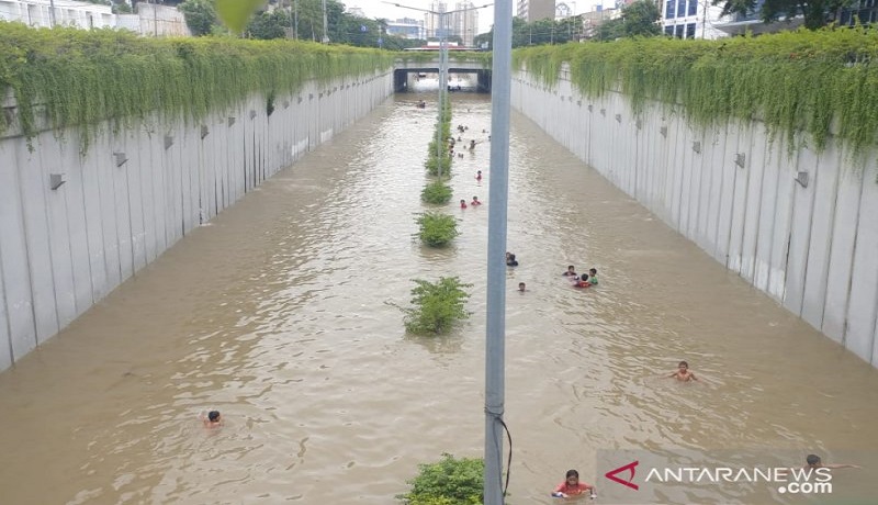 Keseruang anak-anak berenan di Underpass Angkasa yang terendam banjir. Foto: Antara Keseruang anak-anak berenan di Underpass Angkasa yang terendam banjir. Foto: Antara