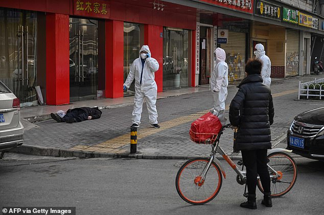 Petugas kesehatan menangangi warga Wuhan yang meninggal di jalan karena terjangkit virus Corona. Foto: AFP via Getty Images Petugas kesehatan menangangi warga Wuhan yang meninggal di jalan karena terjangkit virus Corona. Foto: AFP via Getty Images