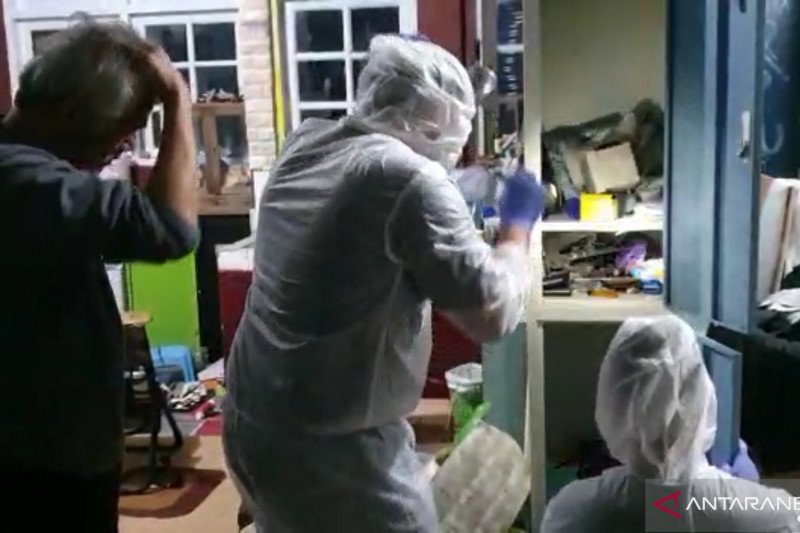 Polisi pakai APD lengkat saat menggeledah rumah Tio Pakusadewo. Foto: Antara Polisi pakai APD lengkat saat menggeledah rumah Tio Pakusadewo. Foto: Antara