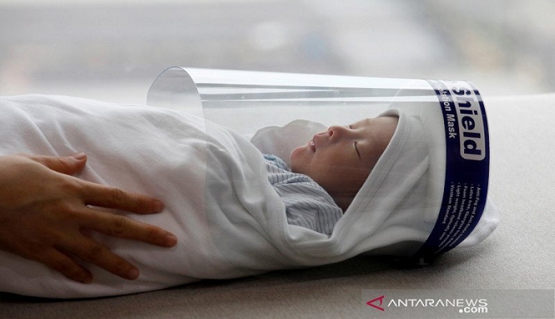 Bayi yang baru lahir, Phuc An, dengan memakai pelindung wajah. Foto: Antara Bayi yang baru lahir, Phuc An, dengan memakai pelindung wajah. Foto: Antara