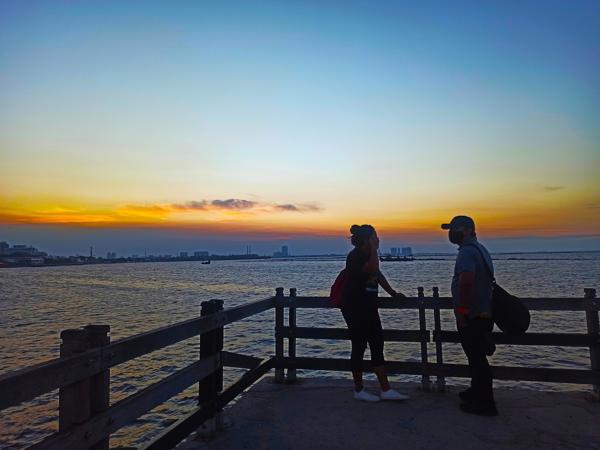 Sepasang kekasih menikmati matahari terbenam di Pantai Ancol (Foto: Andi Ristanto/GenPI.co) Sepasang kekasih menikmati matahari terbenam di Pantai Ancol (Foto: Andi Ristanto/GenPI.co)