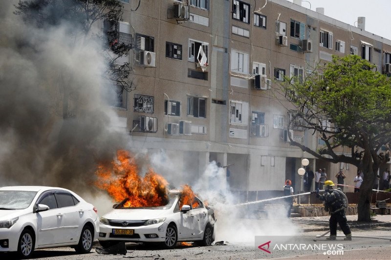 Petugas pemadam kebakaran Israel memadamkan mobil yang terbakar, setelah sebuah roket diluncurkan dari Jalur Gaza, di Ashkelon, Israel selatan, Selasa (11/5/2021).(Foto: Antara/Reuters)/Nir Elias/FOC/sa. Petugas pemadam kebakaran Israel memadamkan mobil yang terbakar, setelah sebuah roket diluncurkan dari Jalur Gaza, di Ashkelon, Israel selatan, Selasa (11/5/2021).(Foto: Antara/Reuters)/Nir Elias/FOC/sa.