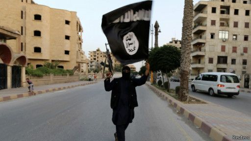 Seorang pejuang membawa senjata dan bendera ISIS. Foto: Reuters. Seorang pejuang membawa senjata dan bendera ISIS. Foto: Reuters.
