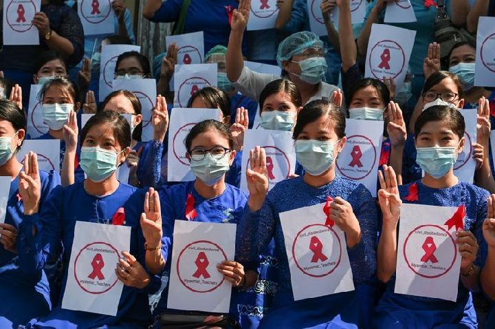 Guru dari Yangon University of Education mengenakan pita merah dan berpose dengan salam tiga jari saat mereka ambil bagian dalam demonstrasi menentang kudeta militer di Yangon, Myanmar, 5 Februari 2021. Foto: Reuters. Guru dari Yangon University of Education mengenakan pita merah dan berpose dengan salam tiga jari saat mereka ambil bagian dalam demonstrasi menentang kudeta militer di Yangon, Myanmar, 5 Februari 2021. Foto: Reuters.