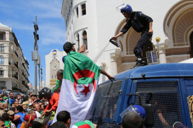 Seorang petugas polisi menyemprotkan gas air mata ke pengunjuk rasa anti-pemerintah di Aljir, Aljazair 17 Mei 2019. Foto: Reuters/Ramzi Boudina/ar. Seorang petugas polisi menyemprotkan gas air mata ke pengunjuk rasa anti-pemerintah di Aljir, Aljazair 17 Mei 2019. Foto: Reuters/Ramzi Boudina/ar.