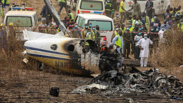 Tim penyelamat dan orang-orang berkumpul di dekat puing-puing pesawat angkatan udara Nigeria, yang menurut menteri penerbangan jatuh saat mendekati landasan pacu bandara Abuja, di Abuja, Nigeria, Minggu (21/2/2021). Foto: Afolabi Sotunde/Reuters. Tim penyelamat dan orang-orang berkumpul di dekat puing-puing pesawat angkatan udara Nigeria, yang menurut menteri penerbangan jatuh saat mendekati landasan pacu bandara Abuja, di Abuja, Nigeria, Minggu (21/2/2021). Foto: Afolabi Sotunde/Reuters.