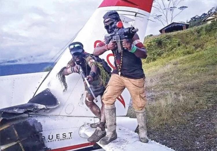 Dua orang yang diduga anggota KKB naik ke puing pesawat sambil menunjukkan senjatanya. (SEBBY SEMBOM FOR CEPOS) Dua orang yang diduga anggota KKB naik ke puing pesawat sambil menunjukkan senjatanya. (SEBBY SEMBOM FOR CEPOS)