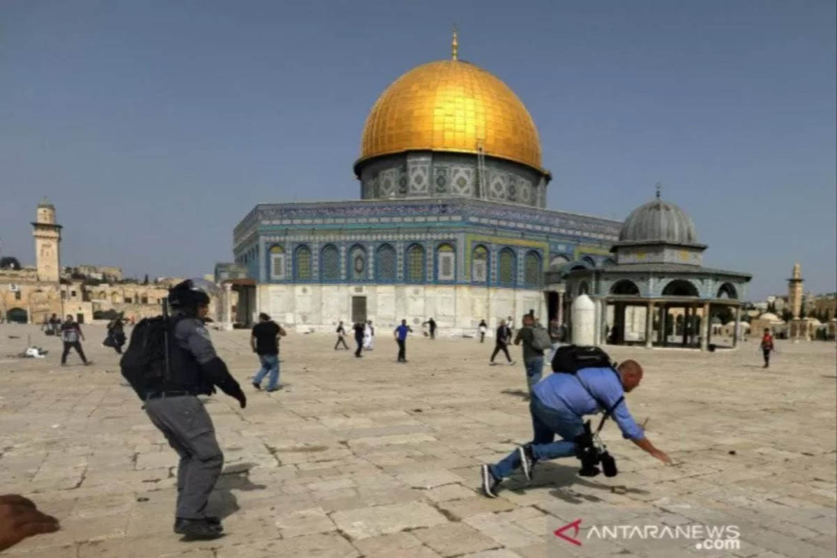 Seorang kameramen terjatuh saat seorang polisi Israel mengejarnya saat terjadi bentrokan dengan warga Palestina di halaman Masjid Al Aqsa. (FOTO: REUTERS) Seorang kameramen terjatuh saat seorang polisi Israel mengejarnya saat terjadi bentrokan dengan warga Palestina di halaman Masjid Al Aqsa. (FOTO: REUTERS)