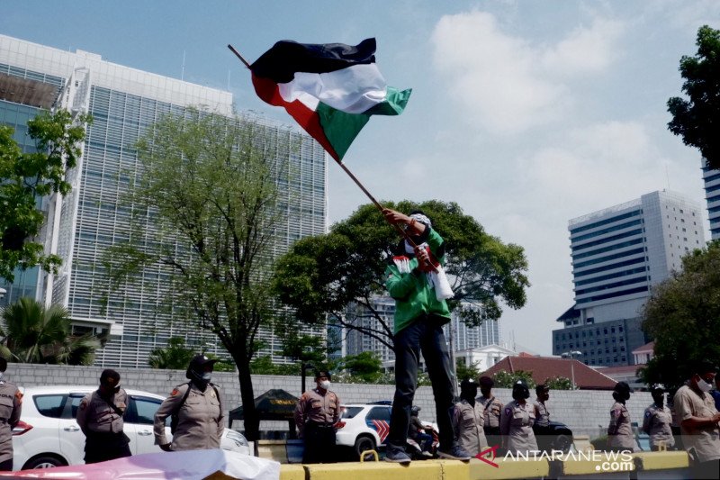 Seorang demonstran mengibarkan bendera Palestina saat berunjuk rasa di depan Kedutaan Besar Amerika Serikat, di Jakarta, Selasa (18/5/2021). (ANTARA/Genta Tenri Mawangi) Seorang demonstran mengibarkan bendera Palestina saat berunjuk rasa di depan Kedutaan Besar Amerika Serikat, di Jakarta, Selasa (18/5/2021). (ANTARA/Genta Tenri Mawangi)