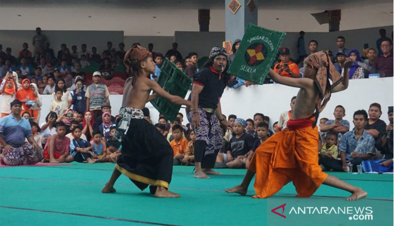 Dua orang remaja adu pukul menggunakan rotan sambil membawa tameng terbuat dari kulit sapi (peresean) dalam pagelaran peresean dan pepaosan di gedung budaya Narmada, Kabupaten Lombok Barat, NTB, Senin (22/7). (Sumber foto: ANTARA/Awaludin) Dua orang remaja adu pukul menggunakan rotan sambil membawa tameng terbuat dari kulit sapi (peresean) dalam pagelaran peresean dan pepaosan di gedung budaya Narmada, Kabupaten Lombok Barat, NTB, Senin (22/7). (Sumber foto: ANTARA/Awaludin)