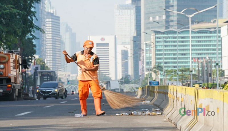 Suyato, petugas pasukan orange sedang membersihkan sampah sisa demo di depan Gedung Bawaslu, Jakarta. Foto: Ririn Suyato, petugas pasukan orange sedang membersihkan sampah sisa demo di depan Gedung Bawaslu, Jakarta. Foto: Ririn